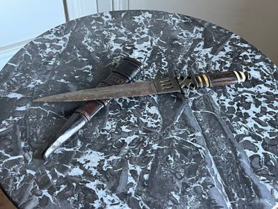 a knife on a table with a knife on top of it