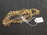 a close up of a gold chain with a price tag on it