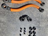 deux tuyaux orange et quelques tuyaux noirs posés sur une surface métallique