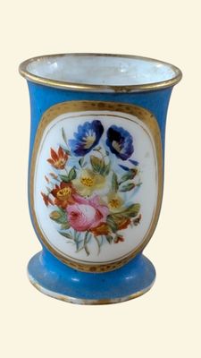 un vase bleu orné de fleurs peintes