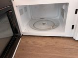 a white microwave with a dirty pan inside of it