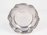 une assiette en argent posée sur une surface blanche