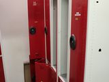 Plusieurs casiers rouges sont alignés en rang dans une pièce