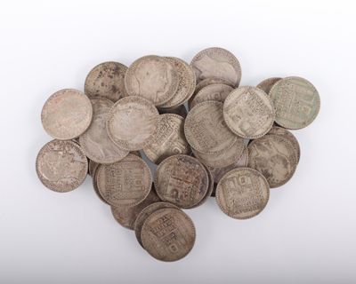 une image représentant un tas de vieilles pièces d'argent posées sur une surface blanche
