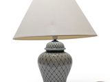 une lampe posée sur une table, munie d'un abat-jour blanc