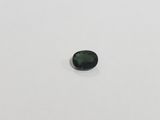 a green tourmaline gems on a white surface