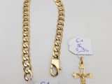 une chaîne en or ornée d'une croix, à côté de deux étiquettes