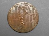 un gros plan d'une médaille de bronze sur laquelle figure une femme
