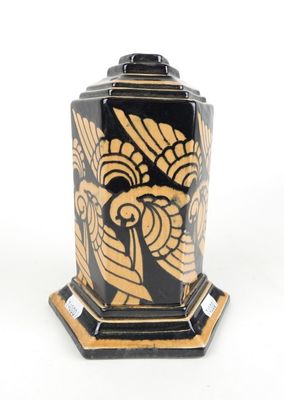 un vase noir et doré orné d'un motif représentant un oiseau