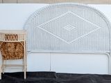 a white wicker headboard and a wicker chair next to a white wall