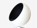 a white ball chair with a black seat on a white pedestal