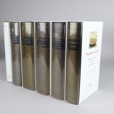 four books are lined up in a row on a gray surface