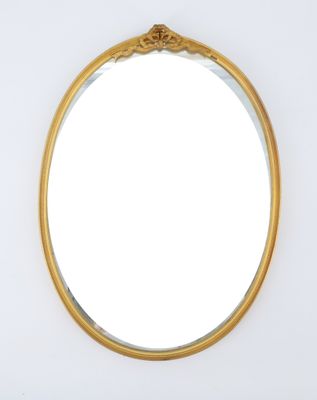 a round mirror with a gold frame on a white wall