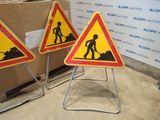 yellow and red road signs on a metal stand in front of a box