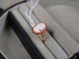 une bague sur laquelle est gravée l'image d'une femme, présentée dans un écrin