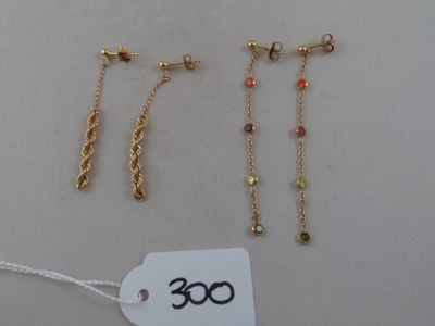 three pairs of gold - plated earrings and a price tag on a white background