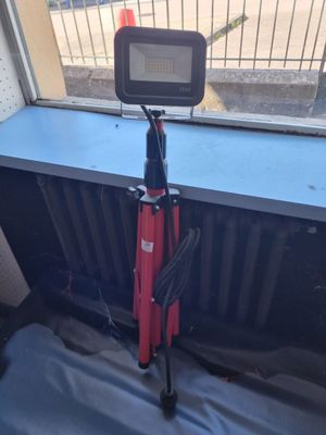 un trépied rouge posé devant une fenêtre