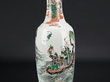 un vase blanc avec un tableau posé sur une table