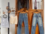 deux paires de jeans suspendues à un portant dans une pièce