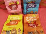 trois sacs de croquettes pour chien posés les uns à côté des autres sur un lit