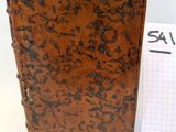 un vieux livre posé à côté d'un bloc-notes sur une surface blanche