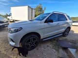 the mercedes gle suv is parked in a lot with a black cat