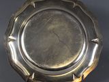 an antique silver plate on a stand on a black background