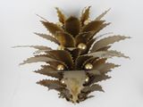 a gold pineapple decoration on a white wall