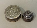 a silver box with a lid sitting next to a silver container