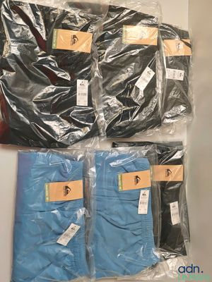 four pairs of men ' s blue and black pants are wrapped in plastic