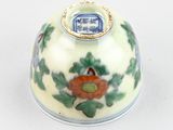 a small white vase with a blue and red design on it