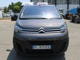 une camionnette Citroën garée sur un parking devant un immeuble