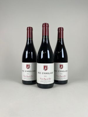 three bottles of red wine sitting on top of a table