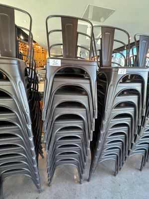 de nombreuses chaises empilées les unes sur les autres dans un magasin