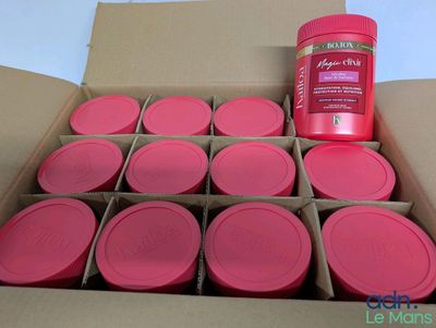 une boîte en carton remplie de bocaux roses et d'une bouteille de liquide