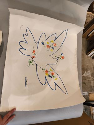 quelqu'un tient un bout de papier sur lequel est dessiné un oiseau