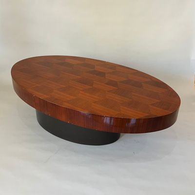 une table basse ovale avec un piètement noir et un plateau en bois
