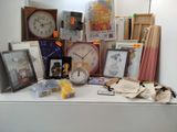une table blanche sur laquelle se trouvent une horloge, des photos, des photos et d'autres objets