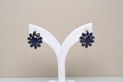 pair of blue and white flower earrings on a white stand