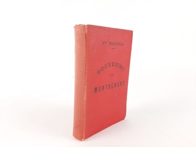 an old red book sitting on top of a white surface