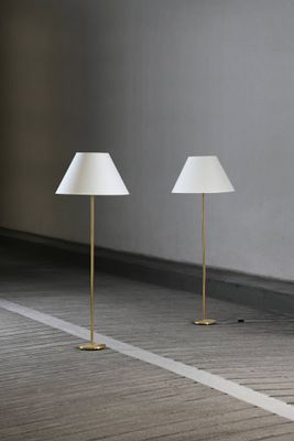 trois lampes dans une pièce aux murs blancs et au sol en bois