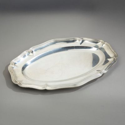 un plateau ovale en argent avec un motif décoratif sur le bord