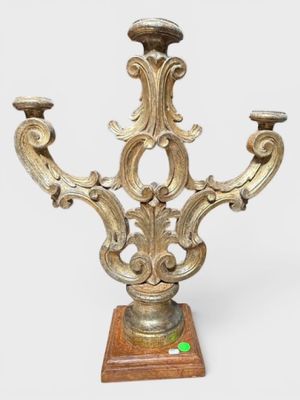 un bougeoir de couleur dorée posé sur un socle en bois