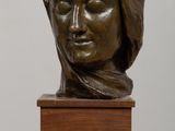 sculpture d'une tête de femme sur une base en bois