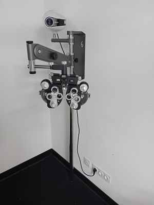 une photo d'une salle d'examen ophtalmologique équipée d'un écran et d'un projecteur