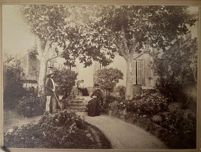 an old black and white photo of a woman and a man in a garden