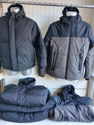 deux vestes et un pantalon sont posés sur une étagère dans une pièce