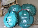 three green bags sitting on the floor next to each other