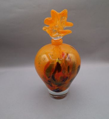a glass vase with a flower on top of it