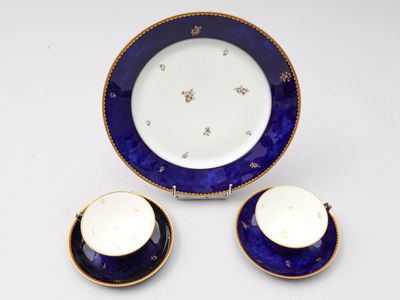 trois pièces de porcelaine bleue et blanche ornées de bordures dorées
